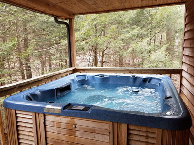 Photo 619_5856.jpg - the hot tub is located on the raised back deck and is completely secluded.  your view is of the woods surrounding you.